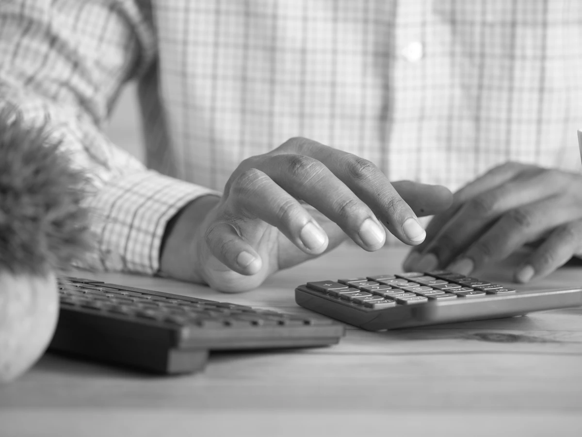 Hands using a calculator at a desk